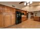 View of kitchen with wood cabinets and black appliances at 14731 W Trading Post Dr, Sun City West, AZ 85375