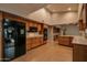 Modern kitchen with wood cabinets, black appliances, and tile flooring at 14731 W Trading Post Dr, Sun City West, AZ 85375