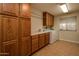 Laundry room with ample wood cabinets and storage at 14731 W Trading Post Dr, Sun City West, AZ 85375