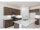 Modern kitchen with island, stainless steel appliances, and dark brown cabinetry at 15382 W Hackamore Dr, Surprise, AZ 85387