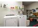 Bright laundry room with washer, dryer, and ample storage shelves at 16148 W Sentinel Dr, Sun City West, AZ 85375