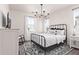 Bright bedroom with metal bed frame, chandelier, and area rug at 17155 W Gracemont St, Surprise, AZ 85388