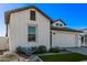 White farmhouse exterior with landscaping and a two-car garage at 17155 W Gracemont St, Surprise, AZ 85388