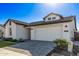 White farmhouse exterior with landscaping and a two-car garage at 17155 W Gracemont St, Surprise, AZ 85388