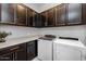 Laundry room with Whirlpool washer and dryer, and dark brown cabinets at 2653 E Marcos Dr, Casa Grande, AZ 85194