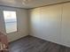 Simple bedroom with grey laminate flooring and a window at 2701 E Allred Ave # 110, Mesa, AZ 85204