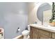 Modern bathroom with a round mirror, wood vanity, and updated fixtures at 3548 E Mesquite St, Gilbert, AZ 85296