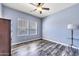 Bright bedroom with wood-look floors, ceiling fan, and large windows at 3548 E Mesquite St, Gilbert, AZ 85296