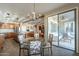 Bright dining room with glass-top table and view into the kitchen and backyard at 36080 W Merced St, Maricopa, AZ 85138