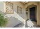 Front entrance with decorative iron wall art and a dark wooden door at 36080 W Merced St, Maricopa, AZ 85138