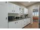 Laundry room with white cabinets, built-in shelves, and modern appliances at 36080 W Merced St, Maricopa, AZ 85138