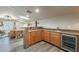 Home wet bar with granite countertop, beverage cooler, and wooden cabinets at 36080 W Merced St, Maricopa, AZ 85138