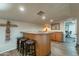 Wet bar with granite countertop, wooden cabinets, and seating for three at 36080 W Merced St, Maricopa, AZ 85138