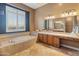 Bathroom boasts a soaking tub, double vanity, and a large mirror at 42405 N Anthem Creek Dr, Anthem, AZ 85086