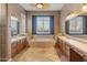 Elegant bathroom with double vanities, a large soaking tub, and tile flooring at 42405 N Anthem Creek Dr, Anthem, AZ 85086