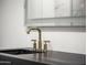 Modern bathroom featuring gold fixtures, dark countertops, and an illuminated, mirrored wall cabinet at 4825 N 72Nd Way, Scottsdale, AZ 85251