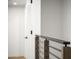 Hallway upstairs featuring modern railing with metal rods and wood posts, and a partially visible door at 4825 N 72Nd Way, Scottsdale, AZ 85251