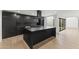 Modern kitchen featuring a center island, sleek black cabinets, and light hardwood floors at 4825 N 72Nd Way, Scottsdale, AZ 85251