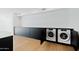 Modern laundry room with stacked washer and dryer, and black cabinetry at 4825 N 72Nd Way, Scottsdale, AZ 85251