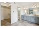 Main bathroom with dual sinks, toilet, and walk-in closet at 4842 E Surrey Ave, Scottsdale, AZ 85254