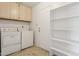 Laundry room with washer, dryer, shelving, and cabinets at 4842 E Surrey Ave, Scottsdale, AZ 85254