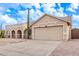 Tan house with a two-car garage and cacti in front at 4963 E Hobart St, Mesa, AZ 85205