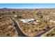 Aerial view showcasing a house, pool, and surrounding desert landscape at 51008 N 295Th Ave, Wickenburg, AZ 85390