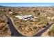 Aerial view showing home's location on a hillside with desert landscape and access road at 51008 N 295Th Ave, Wickenburg, AZ 85390