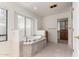 Bathroom with a large tub, tiled floor, and wooden cabinetry at 51008 N 295Th Ave, Wickenburg, AZ 85390