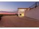 House exterior view at dusk showing the driveway and landscape at 51008 N 295Th Ave, Wickenburg, AZ 85390