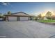 Three-car garage home with a large driveway and manicured lawn at 5133 W Monte Cristo Ave, Glendale, AZ 85306