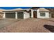 White two-story house with two-car garage and desert landscaping at 6102 W Whispering Wind Dr, Glendale, AZ 85310