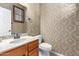 Small bathroom with patterned wallpaper and updated fixtures at 6845 S 7Th Ln, Phoenix, AZ 85041