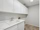 Bright laundry room with white cabinets and a utility sink at 687 E Cleveland Ct, San Tan Valley, AZ 85140