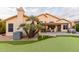 Home features putting green, covered patio, and mature landscaping at 7860 W Taro Ln, Glendale, AZ 85308