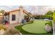 Putting green, patio, and lush landscaping highlight this backyard at 7860 W Taro Ln, Glendale, AZ 85308