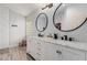 Modern bathroom with double vanity, large mirrors, and walk-in shower at 7860 W Taro Ln, Glendale, AZ 85308