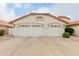 Two-car garage with white doors and Spanish-style design at 7860 W Taro Ln, Glendale, AZ 85308