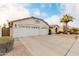 Two-car garage, desert landscaping, and Spanish-style architecture at 7860 W Taro Ln, Glendale, AZ 85308