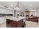 Open kitchen with island, white cabinets, and stainless steel appliances at 7860 W Taro Ln, Glendale, AZ 85308