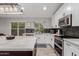 Modern kitchen features white cabinets, quartz countertops, and stainless steel appliances at 7860 W Taro Ln, Glendale, AZ 85308