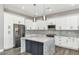 Modern kitchen with white cabinets, large island, and stainless steel appliances at 8712 W Sequoia Dr, Peoria, AZ 85382