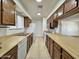 Galley kitchen with wood cabinets, white appliances, and tile floor at 8738 W Tinajas Dr, Arizona City, AZ 85123