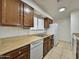 Kitchen boasts wood cabinets, a dishwasher, and a white refrigerator at 8738 W Tinajas Dr, Arizona City, AZ 85123