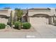 Tan stucco house with two-car garage and desert landscaping at 8965 E Maple Dr, Scottsdale, AZ 85255