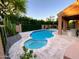 Sparkling swimming pool and jacuzzi surrounded by an elegant tile patio and mature landscaping at 9672 E Davenport Dr, Scottsdale, AZ 85260