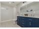 Bathroom with a navy vanity, dual sinks, and a walk-in shower at 1022 E Mariposa St, Phoenix, AZ 85014