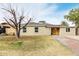 Newly renovated tan house with an orange door and a tree in the front yard at 1022 E Mariposa St, Phoenix, AZ 85014