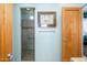 A walk-in shower with a glass door in a bathroom with cool toned walls at 10567 E Mark Ln, Scottsdale, AZ 85262