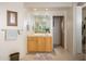 Bright bathroom featuring a light wood vanity, large mirror, and flagstone flooring at 10567 E Mark Ln, Scottsdale, AZ 85262